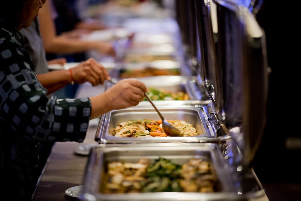 料理の入ったトレーが並べられたバイキング形式の中華料理