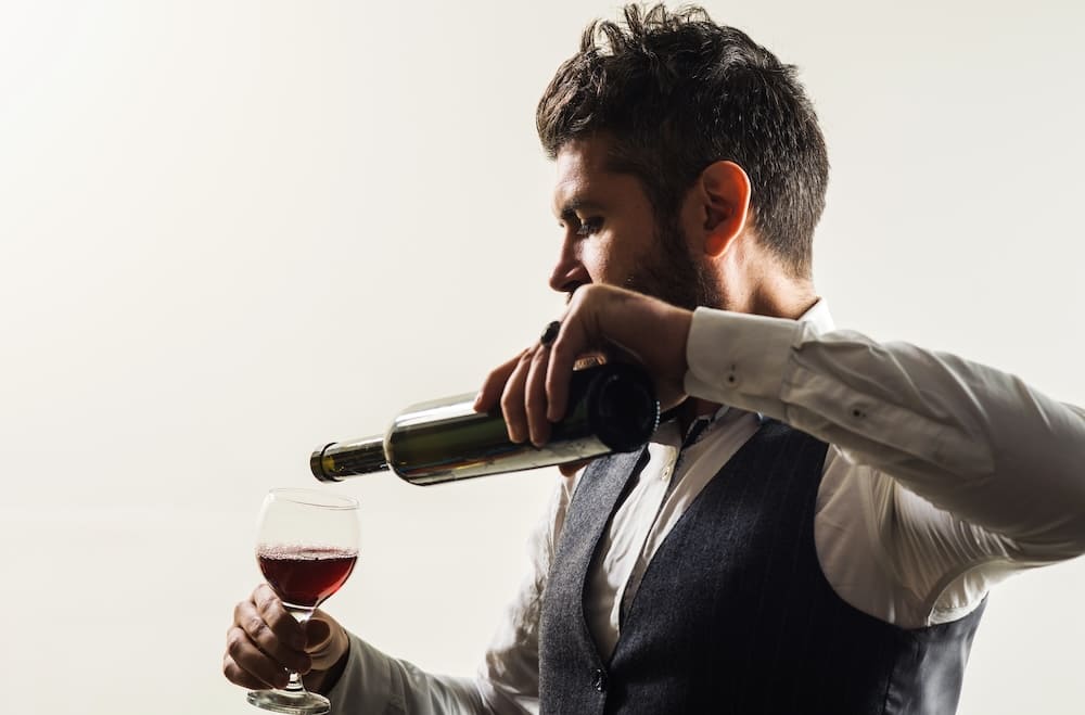 ワイングラスにワインを注ぐ男性ソムリエ