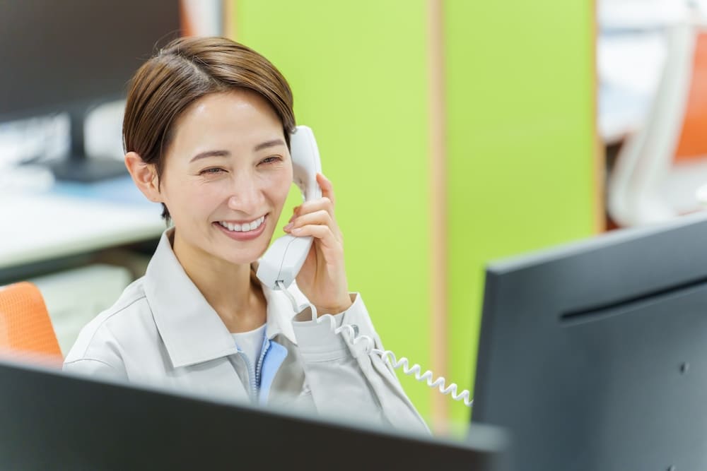電話をする作業服姿の女性
