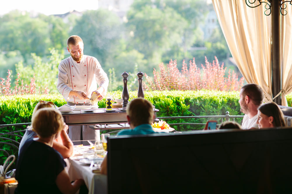 カルパッチョをレストランの客である家族に用意する