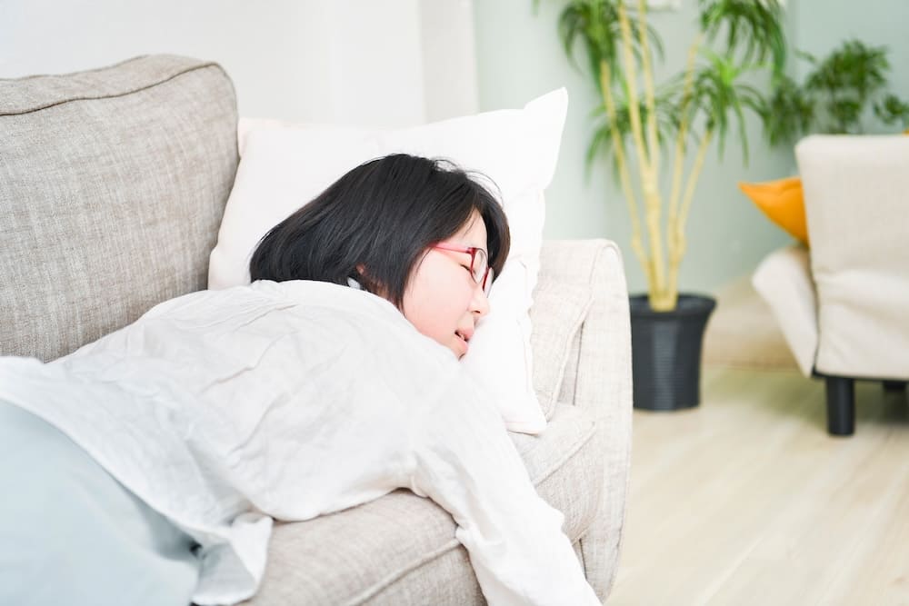 ソファーでダルそうに寝転がる女性