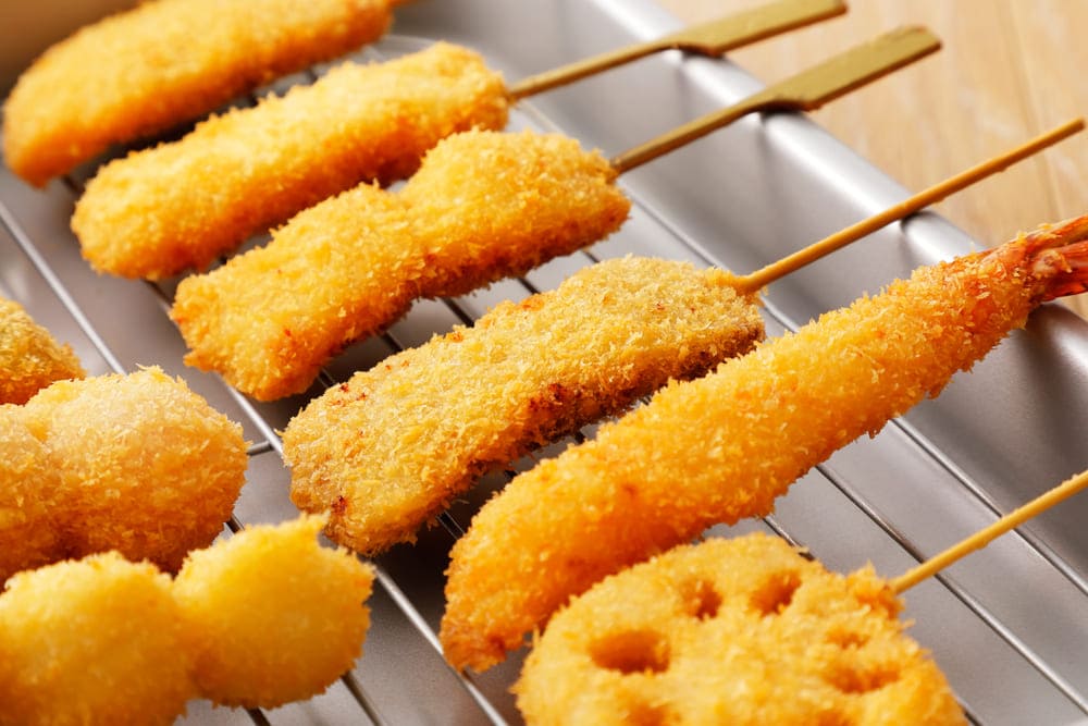 トレーにのった上げられたエビフライ、レンコン、串カツなど