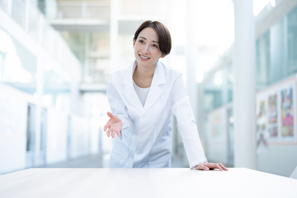 笑顔で説明する白衣を着た女性