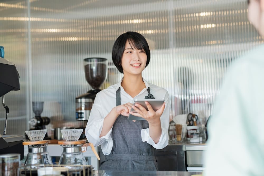 会計をするカフェの女性店員
