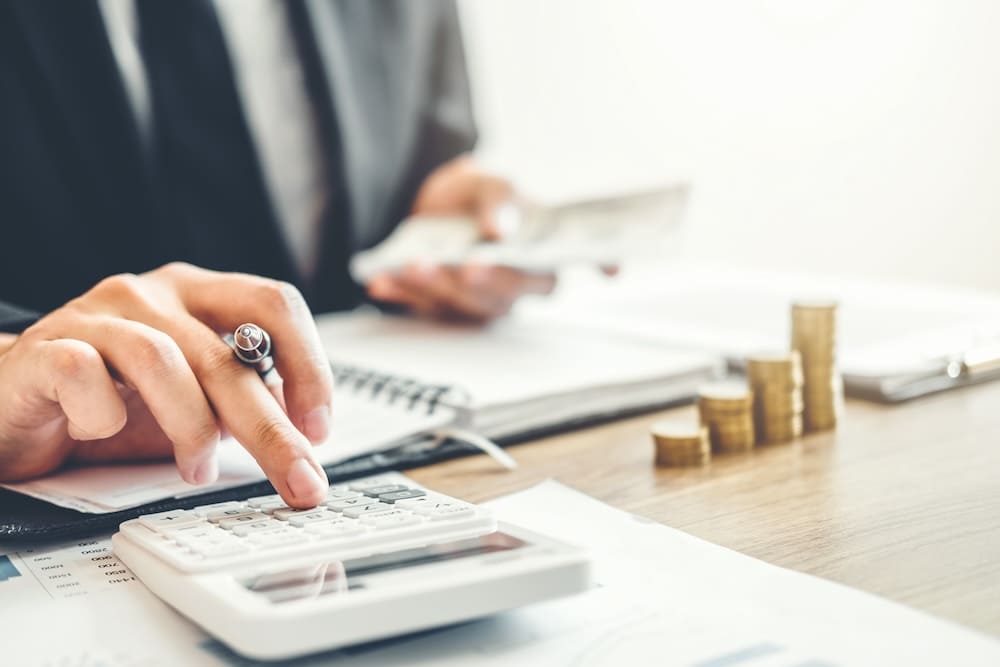 電卓打つ手元と小銭が積み重なっている