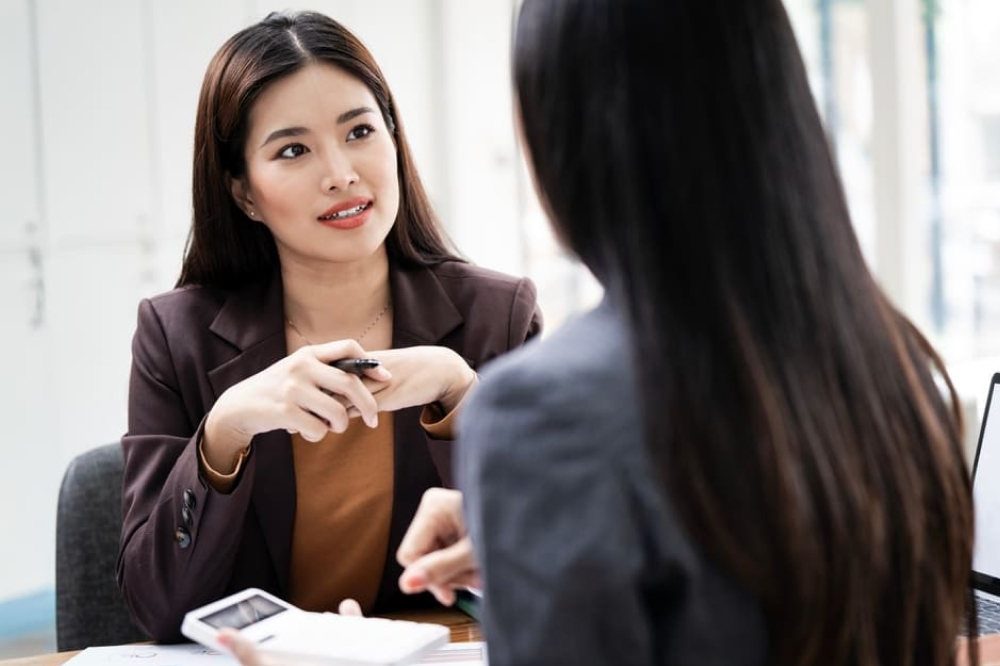 美人な女性が電卓を持った徐栄と真面目に話している