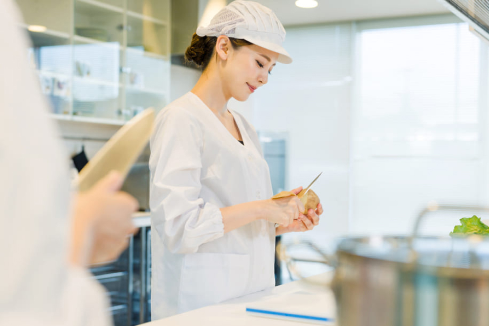 台所で働くアジア人女性の料理スタッフ。