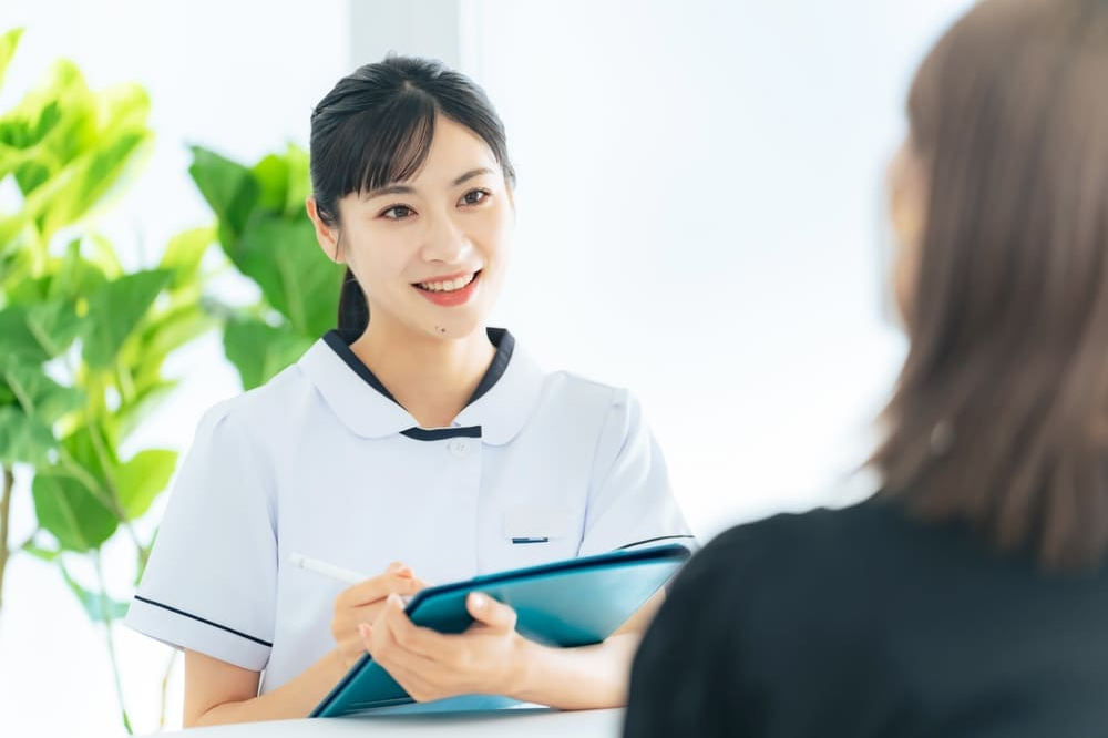 医療施設で患者に面接する女性医療従事者。看護。療法士