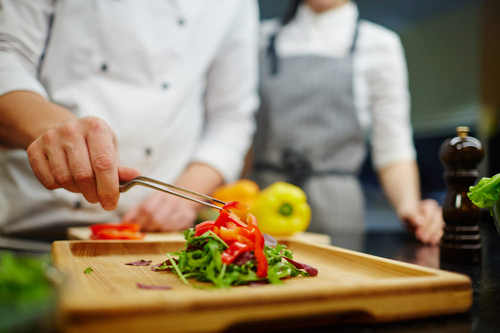 色鮮やかな野菜をもりつける料理人の手元
